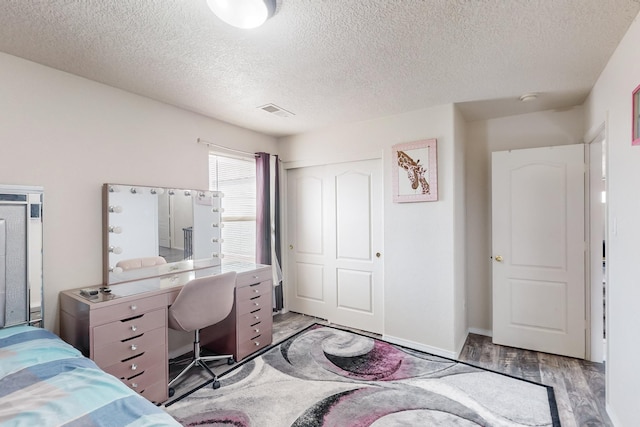 bedroom with a textured ceiling, light hardwood / wood-style flooring, and a closet