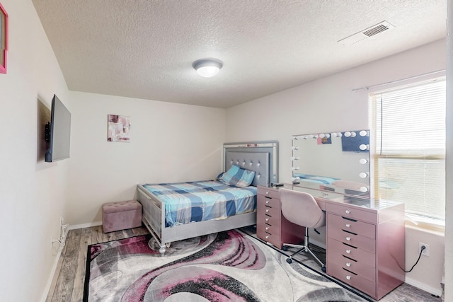 bedroom featuring hardwood / wood-style floors and a textured ceiling