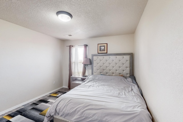 bedroom featuring wood-type flooring and a textured ceiling