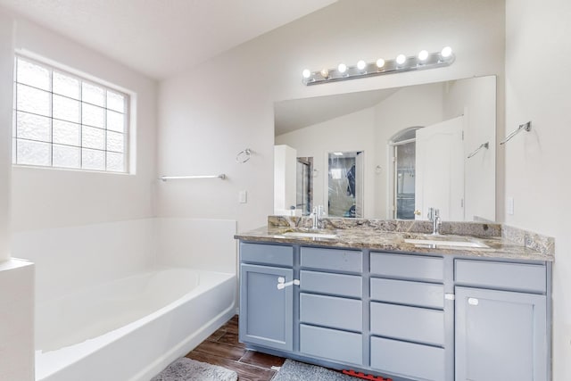 bathroom with vanity, vaulted ceiling, and shower with separate bathtub