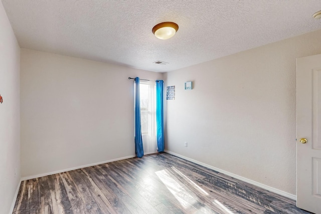 unfurnished room featuring a textured ceiling and dark wood-type flooring