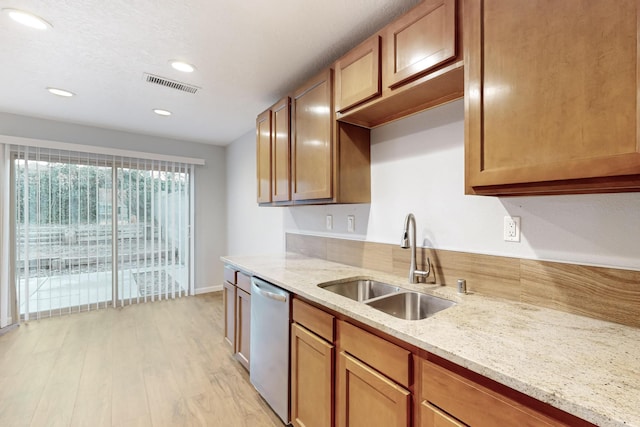 kitchen with stainless steel dishwasher, light stone countertops, sink, and light hardwood / wood-style flooring