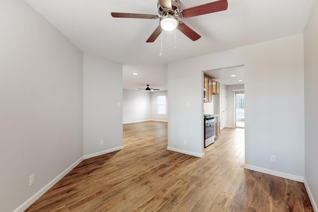 unfurnished room featuring light wood-type flooring, plenty of natural light, and ceiling fan