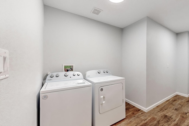 laundry room with light hardwood / wood-style floors and separate washer and dryer