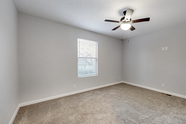 empty room with ceiling fan, carpet, and a textured ceiling