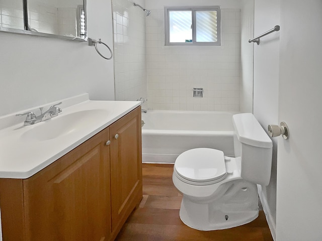 full bathroom with hardwood / wood-style floors, vanity, toilet, and tiled shower / bath combo