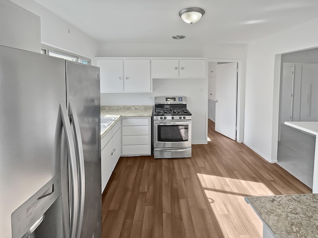 kitchen featuring appliances with stainless steel finishes, white cabinetry, and dark wood-type flooring