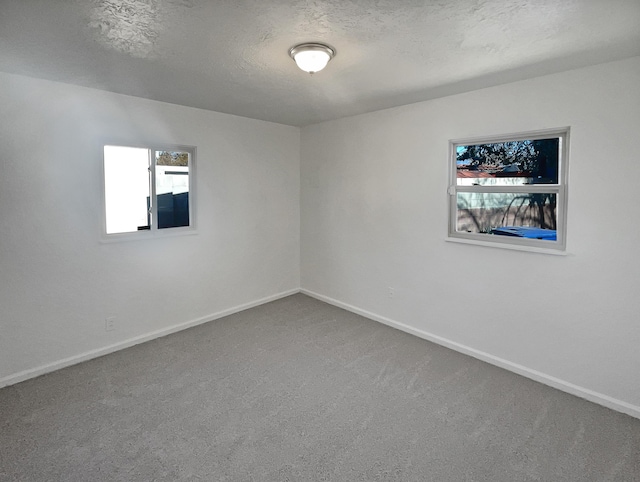 carpeted spare room featuring a textured ceiling