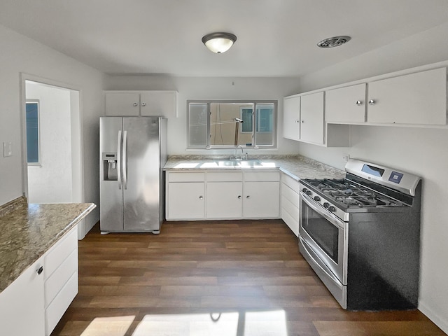 kitchen with light stone countertops, appliances with stainless steel finishes, sink, dark hardwood / wood-style floors, and white cabinetry