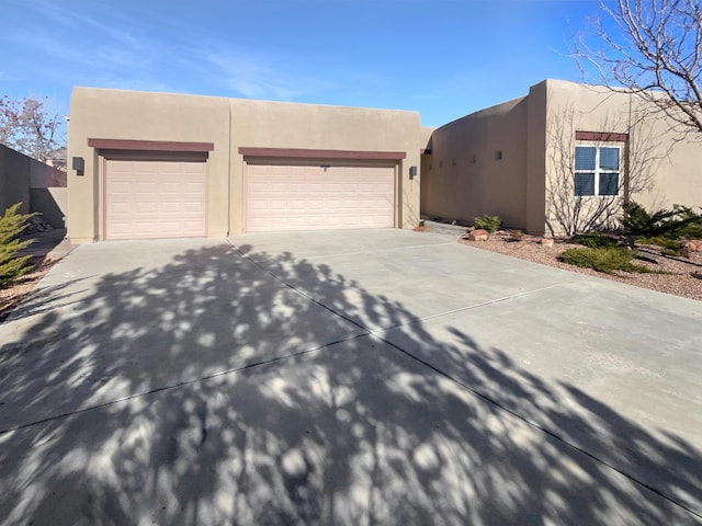 pueblo revival-style home featuring a garage