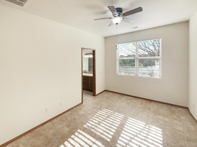 tiled spare room with ceiling fan