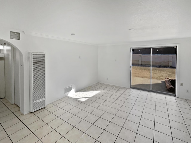 spare room featuring light tile patterned floors and crown molding