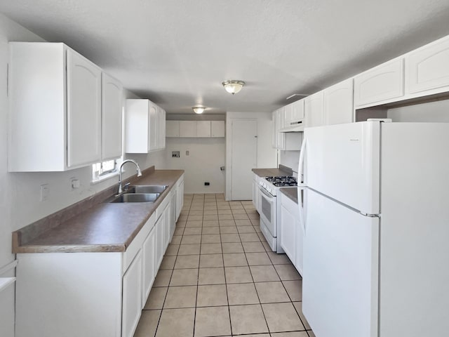 kitchen with white appliances, white cabinets, sink, light tile patterned floors, and custom range hood