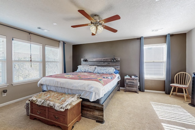 carpeted bedroom with ceiling fan and a textured ceiling