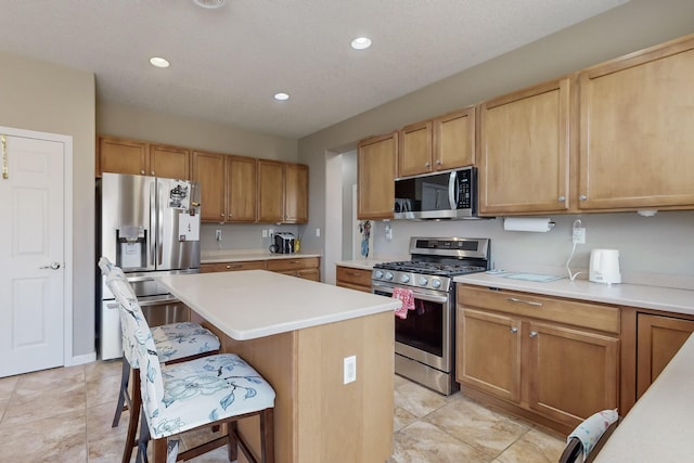 kitchen featuring appliances with stainless steel finishes, a center island, and a kitchen breakfast bar