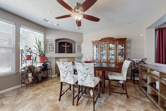 dining room with light tile patterned floors, a textured ceiling, and ceiling fan