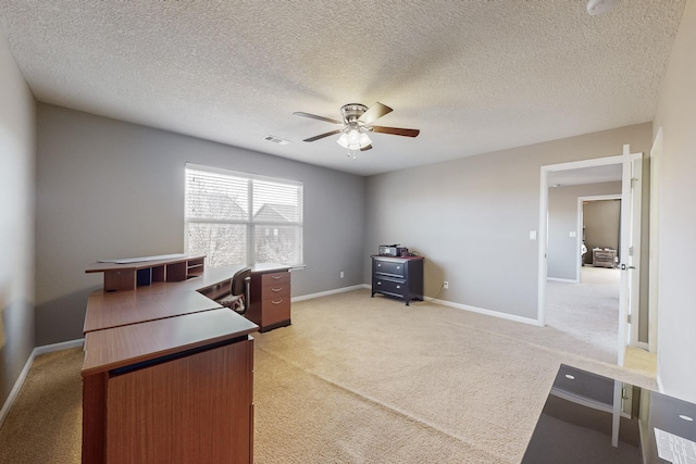 carpeted office featuring ceiling fan and a textured ceiling