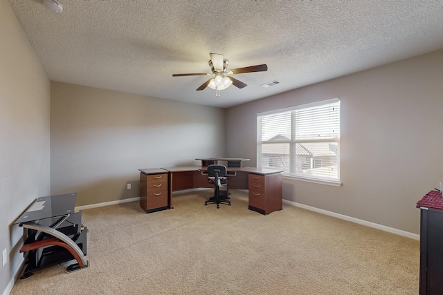 carpeted office with ceiling fan and a textured ceiling