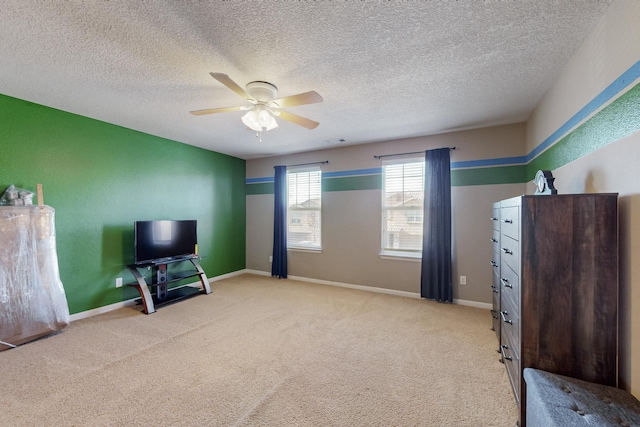 sitting room featuring a textured ceiling, light colored carpet, and ceiling fan