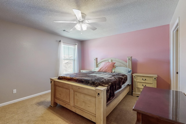 bedroom featuring ceiling fan, light carpet, and a textured ceiling