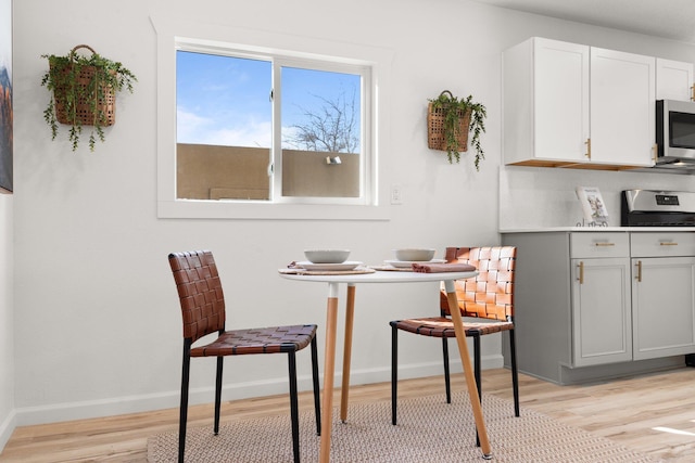 kitchen featuring white cabinets, light wood-type flooring, and range