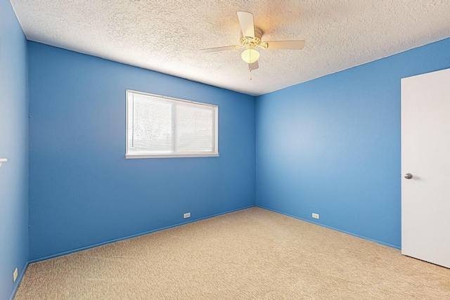 carpeted spare room featuring a textured ceiling and ceiling fan