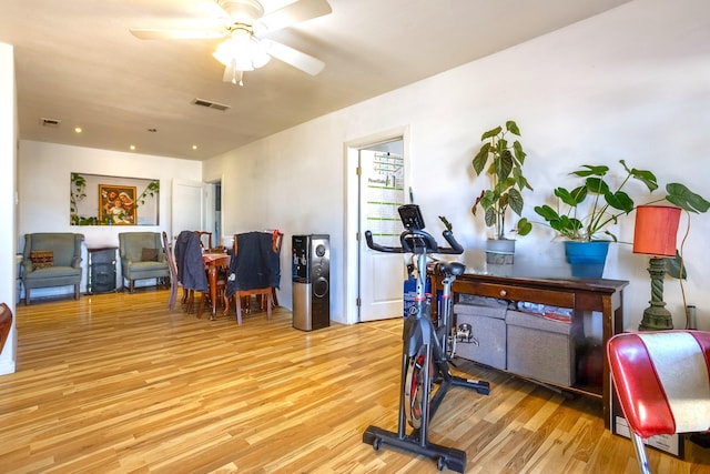 exercise room with a ceiling fan, visible vents, and wood finished floors