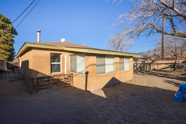 view of home's exterior with fence and stucco siding