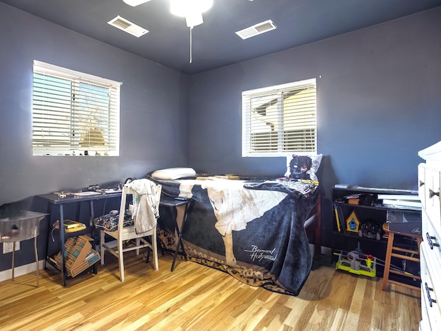 bedroom featuring wood finished floors and visible vents