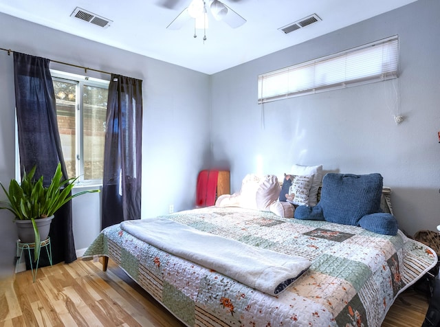 bedroom with visible vents, ceiling fan, and wood finished floors