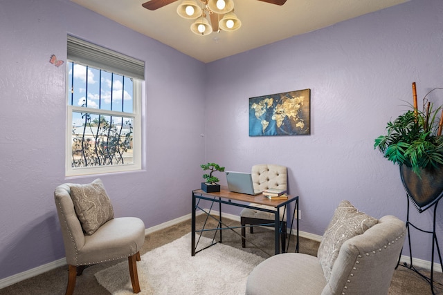 carpeted home office with ceiling fan, a textured wall, and baseboards