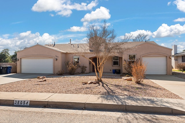 view of front of home featuring a garage, concrete driveway, and stucco siding