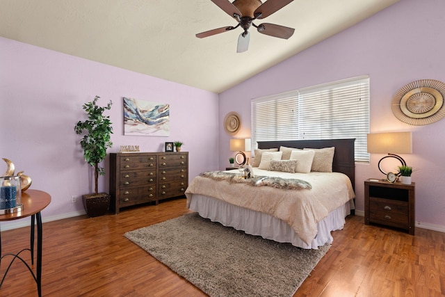 bedroom featuring ceiling fan, baseboards, vaulted ceiling, and wood finished floors