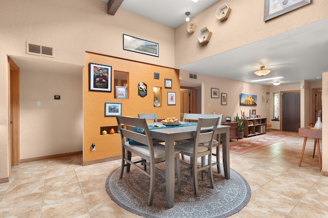 dining space with a towering ceiling and light tile patterned floors