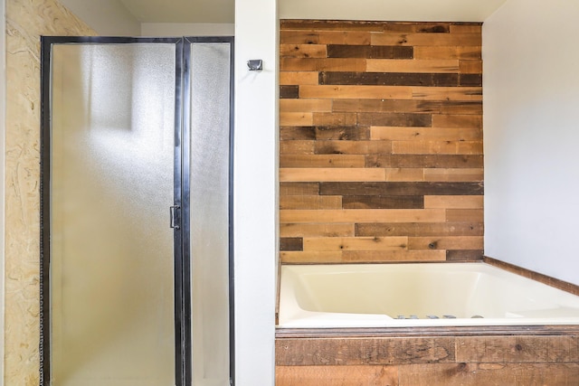 bathroom with shower with separate bathtub and wood walls