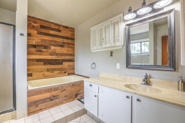 bathroom featuring tile patterned flooring, vanity, wooden walls, and tiled tub