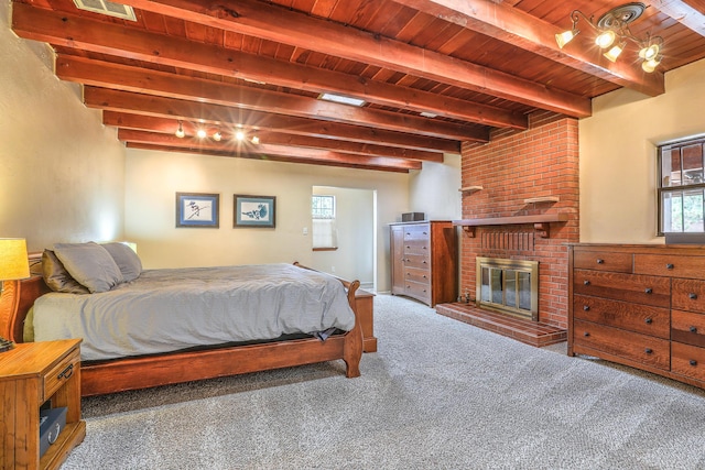 carpeted bedroom featuring beam ceiling, wood ceiling, and a fireplace