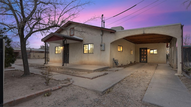 back house at dusk with a carport