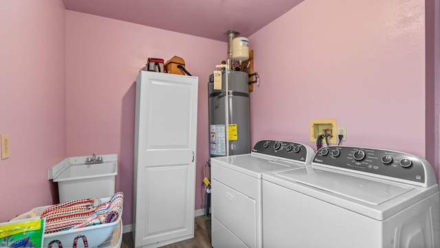 clothes washing area featuring separate washer and dryer, hardwood / wood-style floors, cabinets, and gas water heater