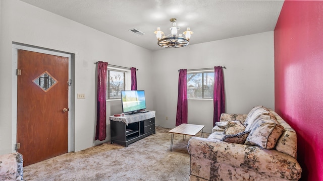 living area with light colored carpet and a chandelier