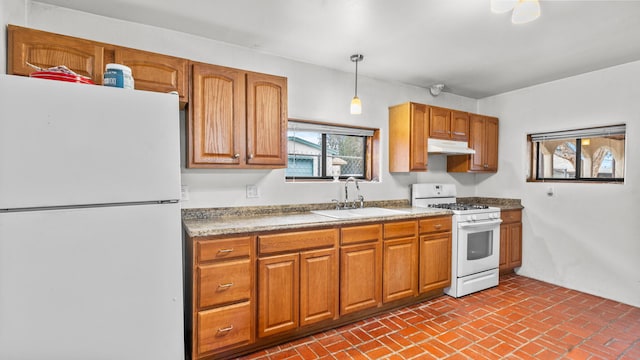 kitchen featuring pendant lighting, white appliances, and sink