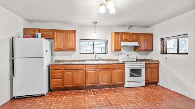 kitchen with white appliances, sink, and hanging light fixtures