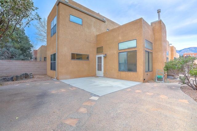 rear view of property featuring a mountain view and a patio area