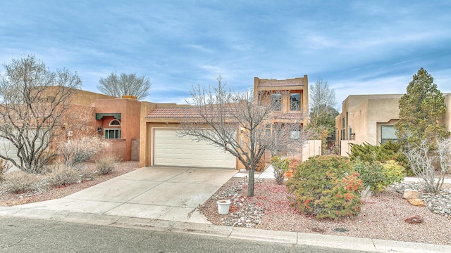 pueblo revival-style home with a garage