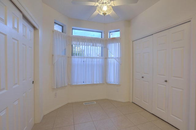 unfurnished bedroom featuring light tile patterned floors and ceiling fan