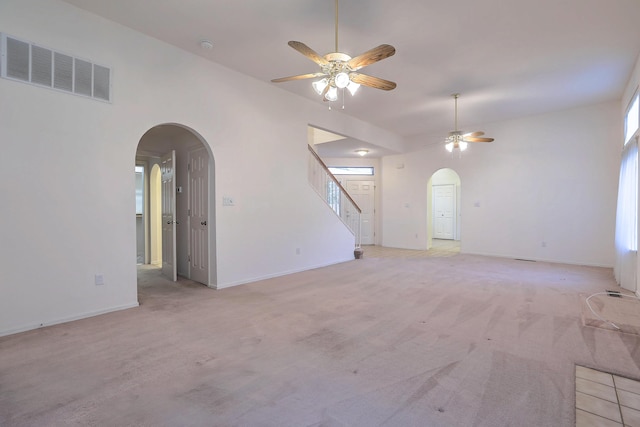 unfurnished living room featuring ceiling fan and light colored carpet