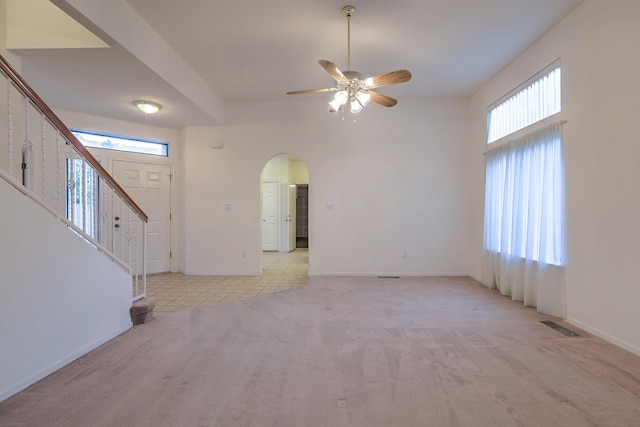 interior space with ceiling fan, a healthy amount of sunlight, and light carpet