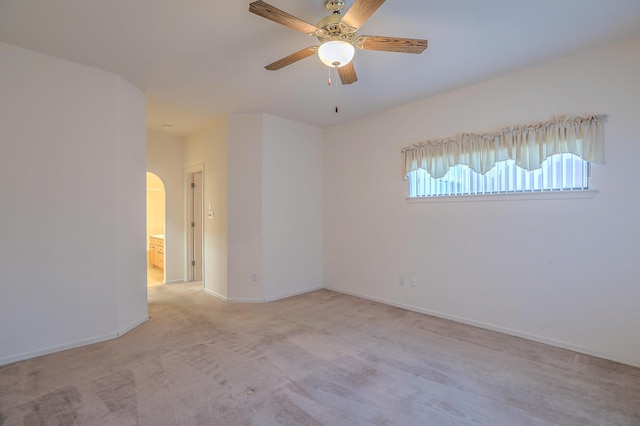 spare room with ceiling fan and light carpet