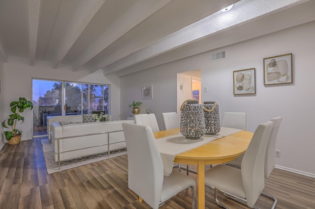 dining room with beamed ceiling and dark hardwood / wood-style floors