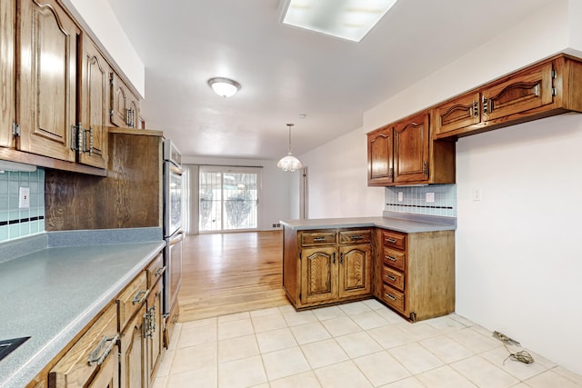 kitchen with pendant lighting, backsplash, and double oven